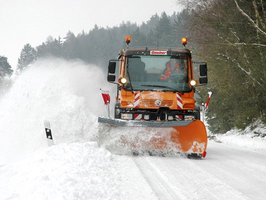 Räumfahrzeug der Schiller Service GmbH im Winterdienst beseitigt Schnee von der Straße